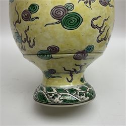 20th century Chinese Famille Verte vase, of slender ovoid form with tapering neck and flared rim, decorated with green and grey enamel with dragons chasing flaming pearls amongst auspicious clouds upon a yellow ground, H30cm