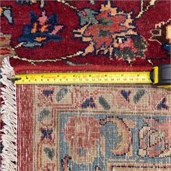 North East Persian Meshed hand-knotted carpet, rich red all-over field of finely decorated with dense scrolling floral sprays and palmettes and flowering vines, enclosed by a broad border in soft pastel tones, flanked by multiple guard borders, with cotton fringe ends  
