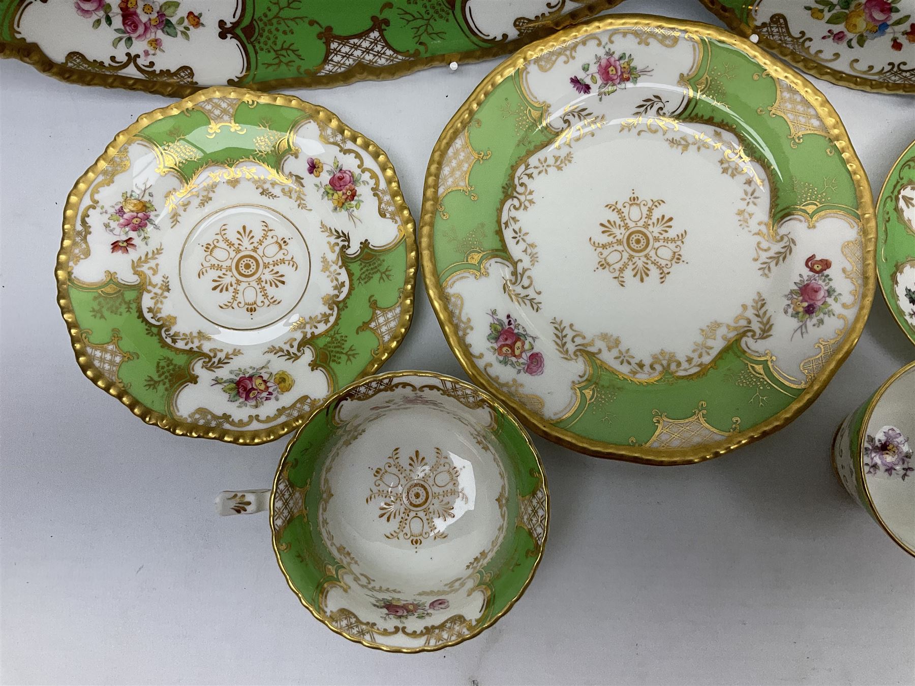 Coalport green batwing pattern tea wares, decorated with finely enamelled floral sprays within gilt reserves, comprising teacup trio, twin handled cake plate and side plate, pattern no Y2665, together with a Coalport for Harrods cup and saucer similarly decorated, the saucer with stamped mark beneath 'Manufactured for Harrods Ltd, Brompton Rd London', all with green Coalport AD 1750 marks beneath, largest W31cm (7)