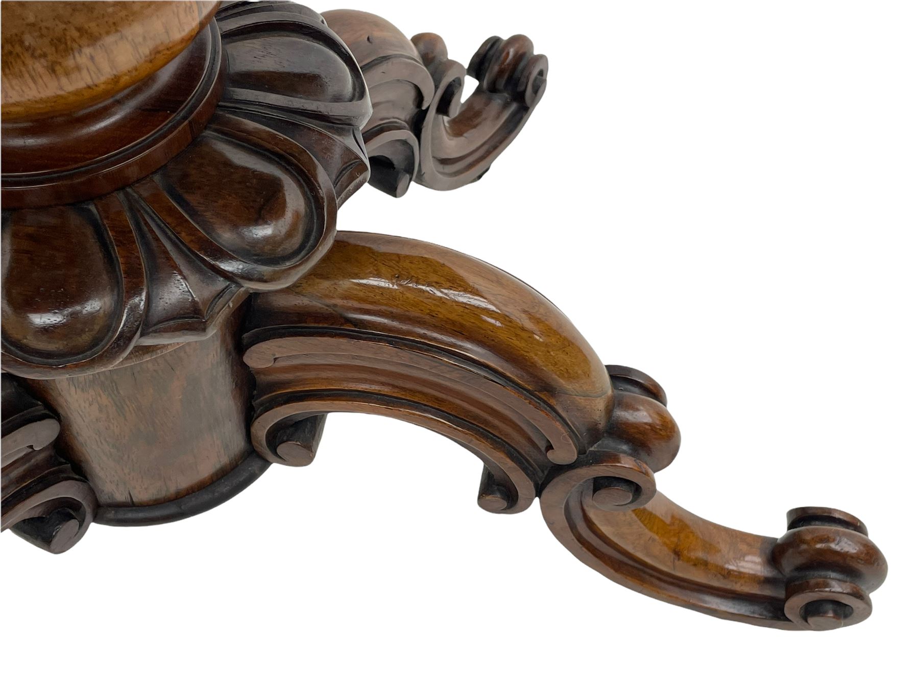 Victorian figured rosewood card table, fold-over swivel top with circular baize lining, moulded frieze with stylised flower head carving to corners, turned column with egg and dart decoration, on quadruple splayed c-scroll carved supports, with brass castors