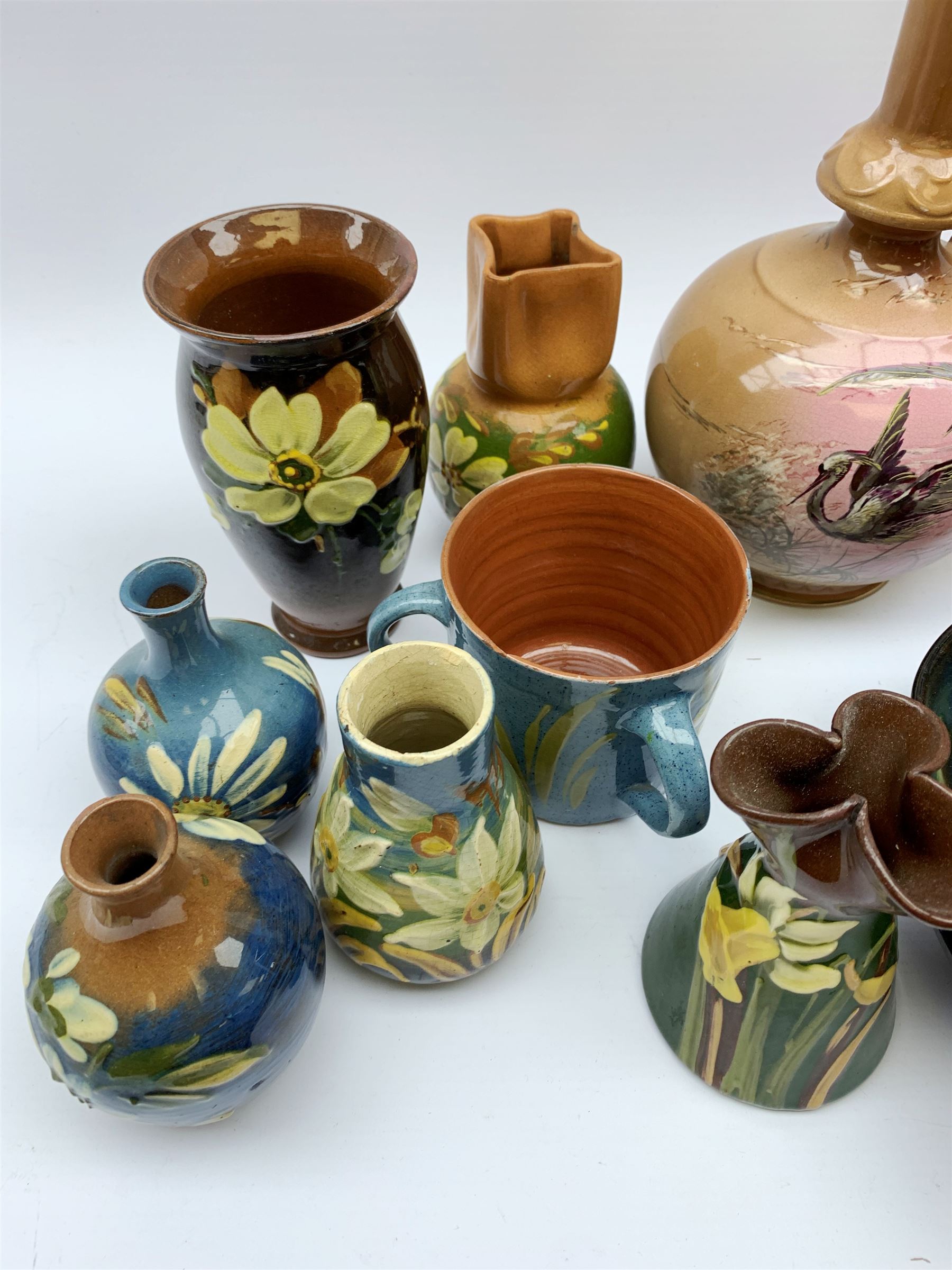 Collection of Devon pottery all having floral slip decoration and