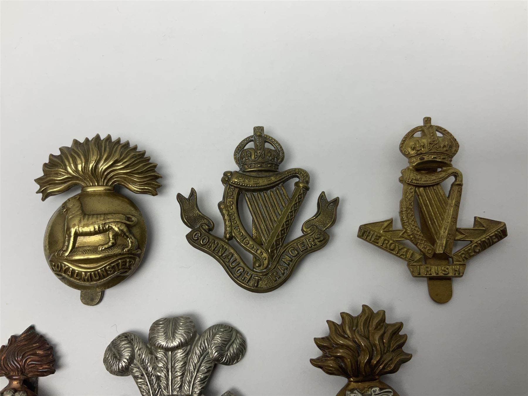 Fourteen cap badges of Irish interest including Royal Dublin Fusiliers inscribed to the slider 'From A. O'Connor 2nd Batt. Dec.2nd 1915', Connaught Rangers, South irish Horse Yeomanry, Inniskilling Fusiliers, Royal Irish Regiment etc; and seven Welsh badges including South Wales Borderers, Welsh Guards, 3rd Bn. Monmouthshire Regt. etc (21)