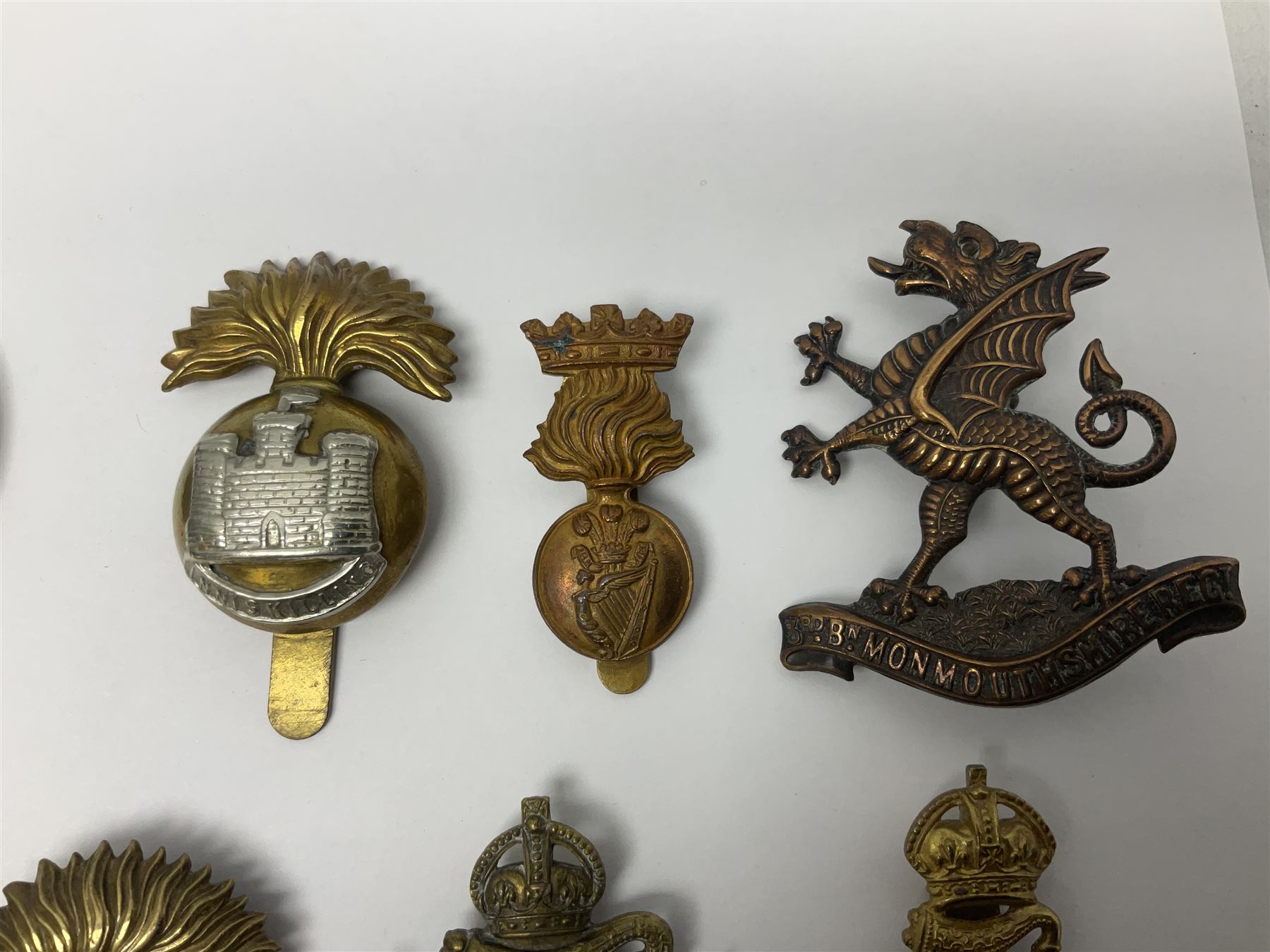 Fourteen cap badges of Irish interest including Royal Dublin Fusiliers inscribed to the slider 'From A. O'Connor 2nd Batt. Dec.2nd 1915', Connaught Rangers, South irish Horse Yeomanry, Inniskilling Fusiliers, Royal Irish Regiment etc; and seven Welsh badges including South Wales Borderers, Welsh Guards, 3rd Bn. Monmouthshire Regt. etc (21)