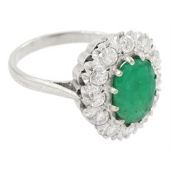 White gold emerald and diamond cluster ring, single oval cut emerald of approx 1.35 carat, surrounded by twelve brilliant cut diamonds, stamped 18ct, total diamond weight approx 0.85 carat
