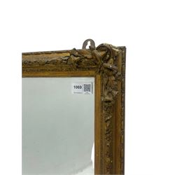 19th century gilt framed wall mirror, the corners decorated with flower heads with extending foliage, plain mirror plate