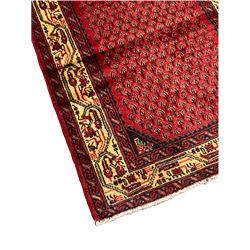Persian Araak red ground runner, the field decorated with repeating Boteh motifs, ivory ground border with stylised decoration guarded by scrolling bands