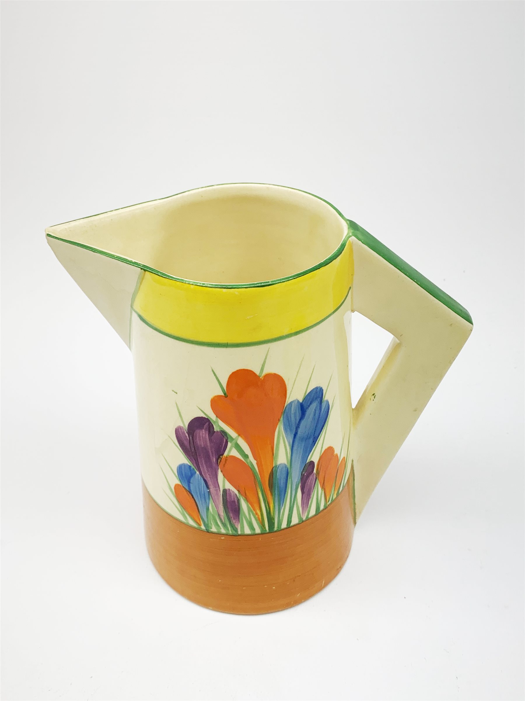 A Clarice Cliff Newport Pottery jug, decorated in the Crocus pattern, H16.5cm, together with a Clarice Cliff Bizarre by Wilkinson Limited octagonal bowl, decorated in the Crocus pattern, D13cm, each with printed marks beneath. 