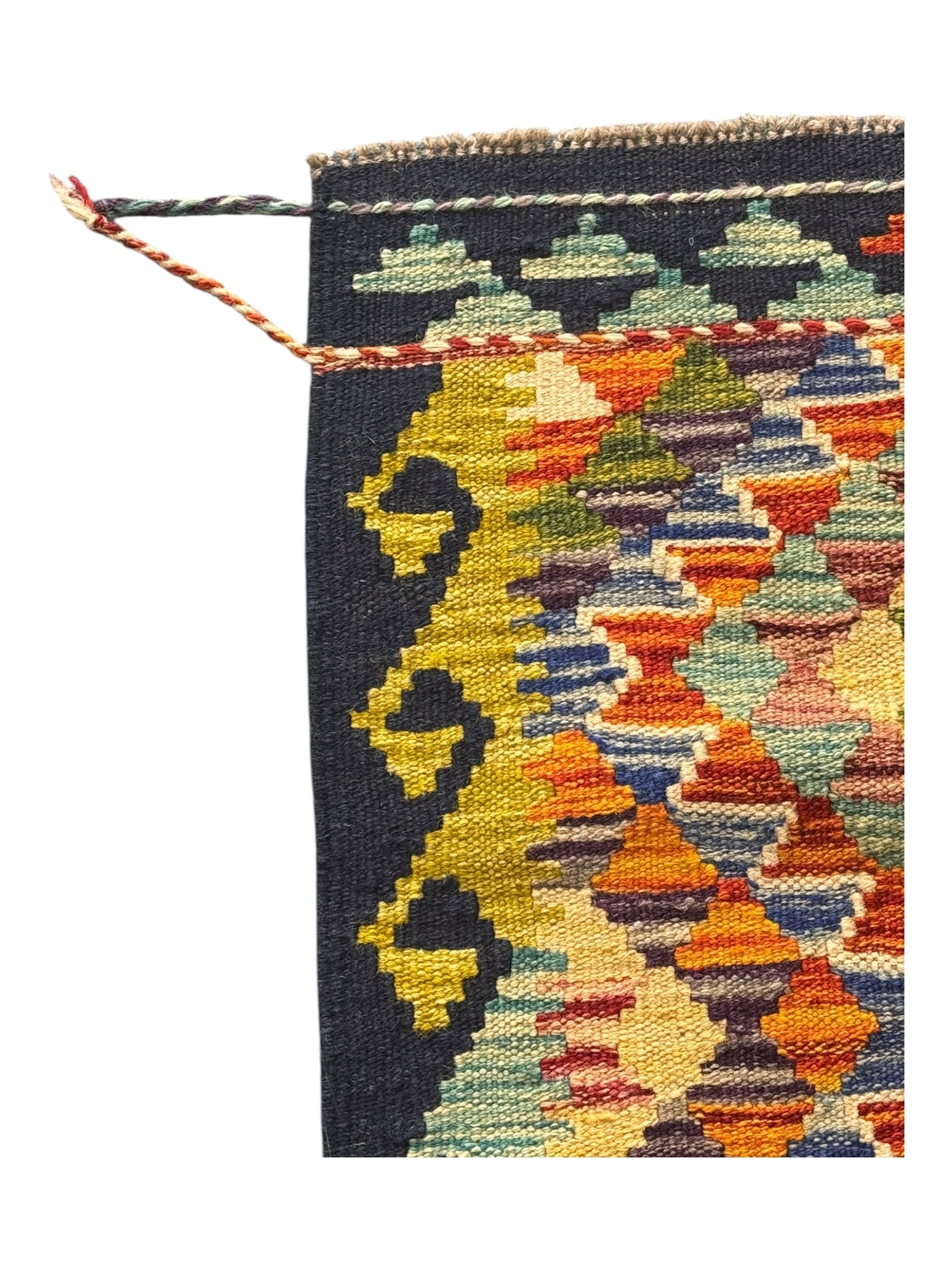 Chobi Kilim flatweave rug, dark navy ground with a vibrant multicoloured diamond lattice, framed by stylised border motifs, braided corner tassels