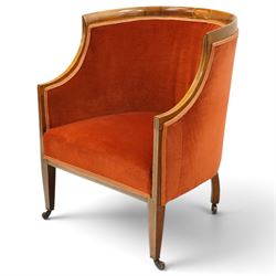 Pair of Edwardian inlaid mahogany tub armchairs, traditional shape with satinwood stringing, upholstered in crimson fabric with sprung seat, on square tapering supports with castors