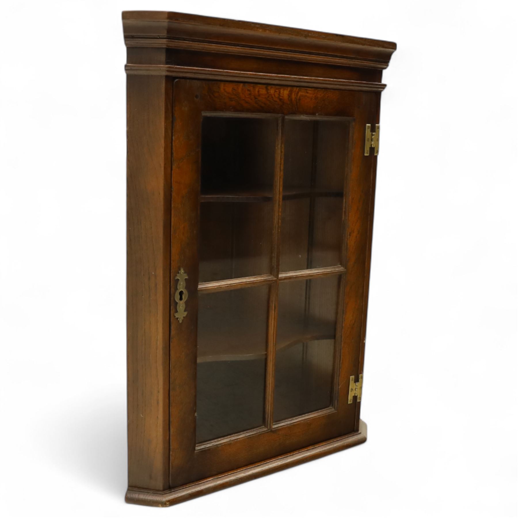 Early 20th century oak wall-mounted corner cabinet, moulded cornice above a single glazed door with six-panel astragal glazing, fitted interior with two shaped shelves