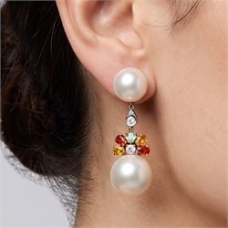 Pair of 14ct white and yellow gold South Sea pearl, diamond and sapphire pendant earrings, each stud set with two pearls, spaced by a single round brilliant cut diamond, suspending a further diamond surrounded by five pear cut yellow, orange and green sapphires, stamped 585