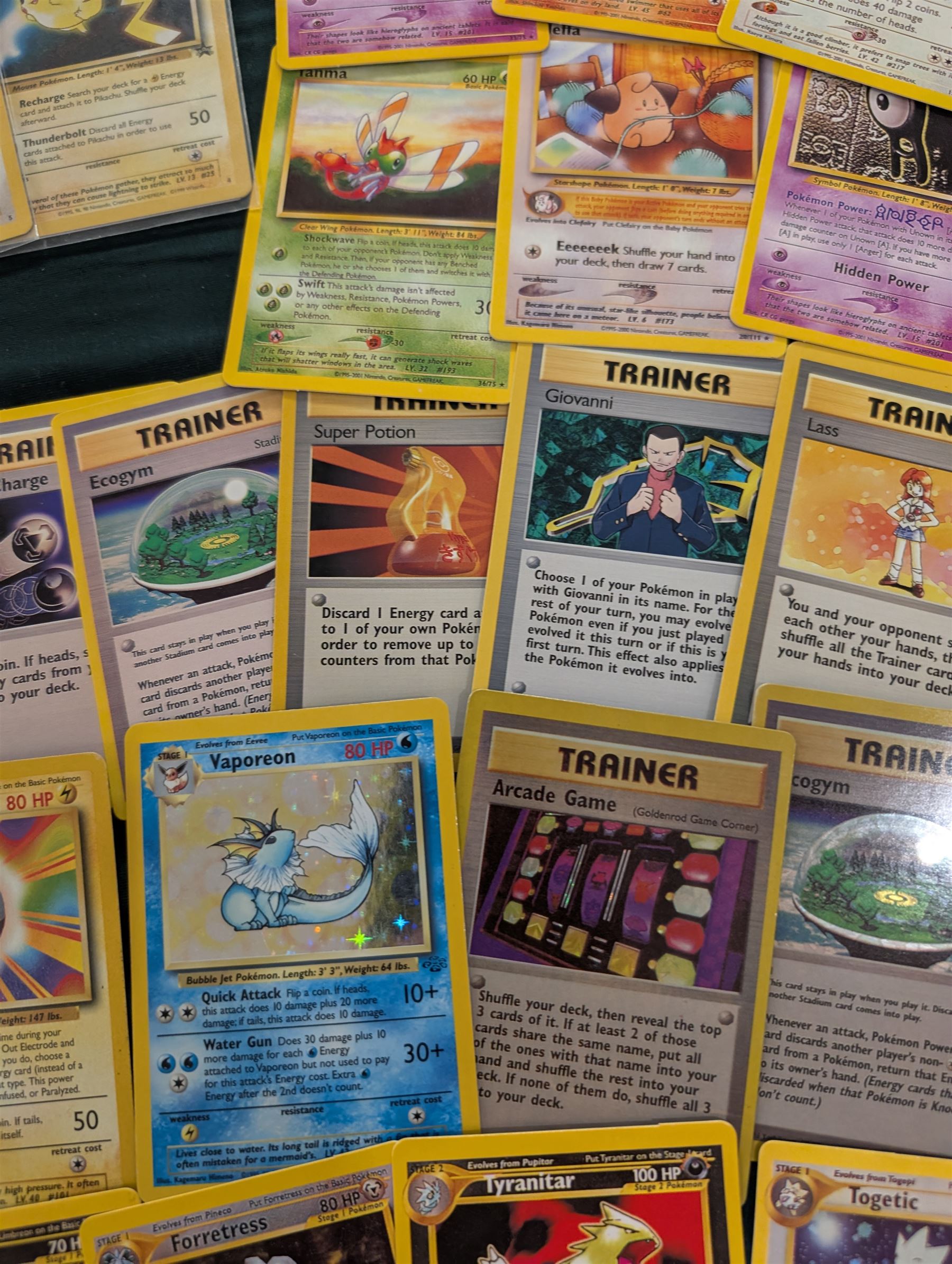 Collection of Pokemon TGC trading cards, including two WB First Movie Black Star promo cards Pikachu no. 4 and Dragonite no. 5, two Ancient Mew Black Star holo promo cards, Gym Challenge Giovanni's Persian 8/132 holo and a small collection WOTC, Neo Discovery and Neo Genesis cards, together with thirty four Bandai Carddass Pokemon cards, including prism Charizard no. 186 and Pokemon Topps cards including holo examples 