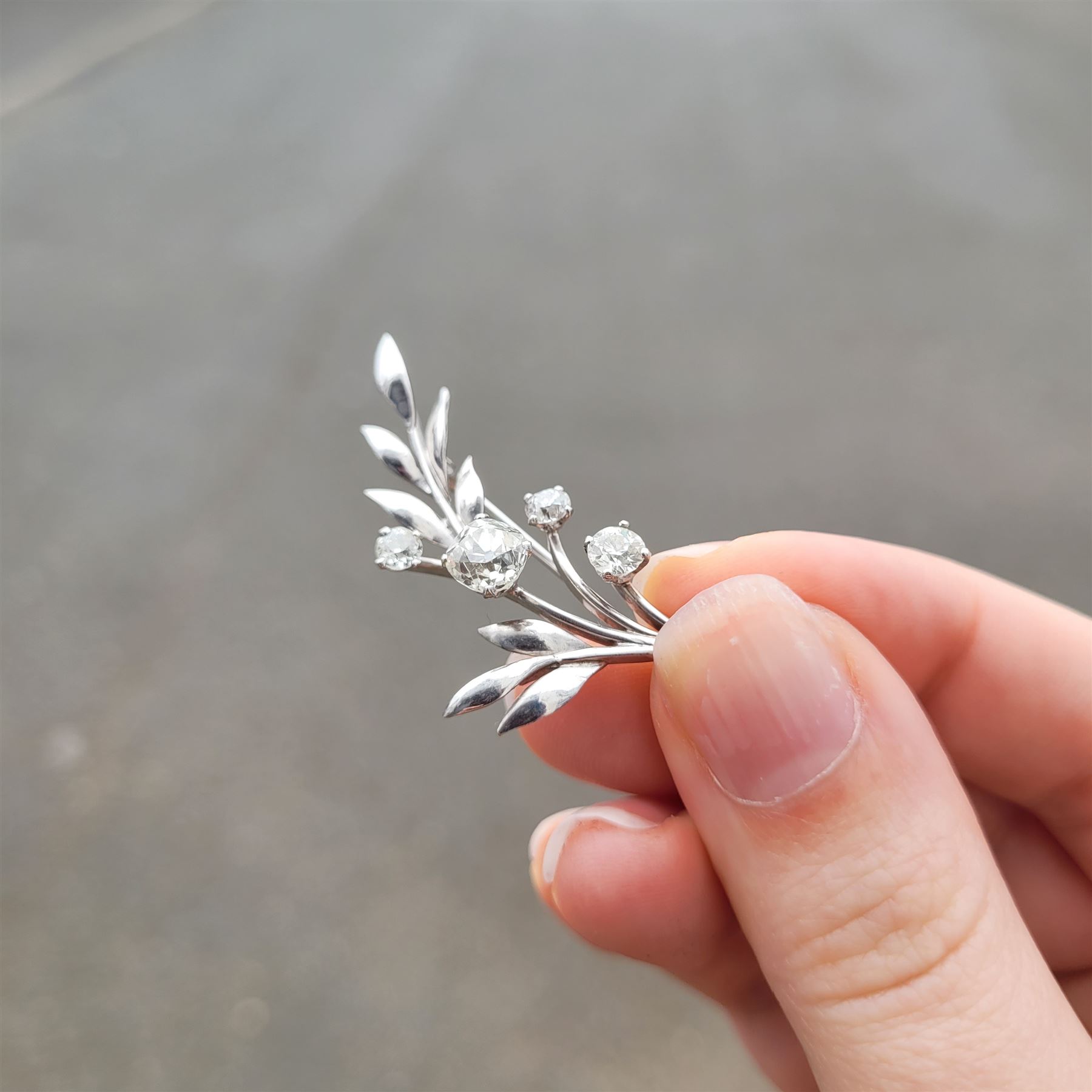 18ct white gold diamond flower brooch, set with a principal old cut diamond of approx 1.00 carat, surrounded by three further old cut diamonds, total diamond weight approx 1.75 carat