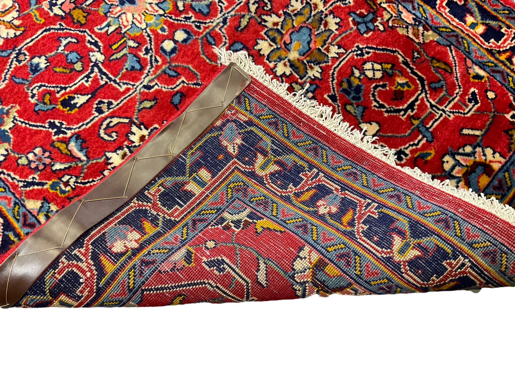 Central Persian Kashan crimson ground runner rug, the field decorated with interlacing branch and stylised flower head motifs, the guarded indigo border with repeating trailing foliate patterns