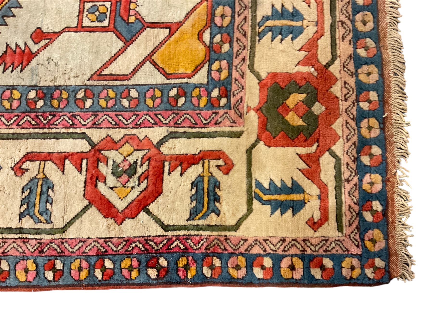 Anatolian Turkish ivory ground carpet, the central geometric pole medallion within an amber field, the guarded border decorated with stylised plant motifs surrounded by bands of repeating flower heads