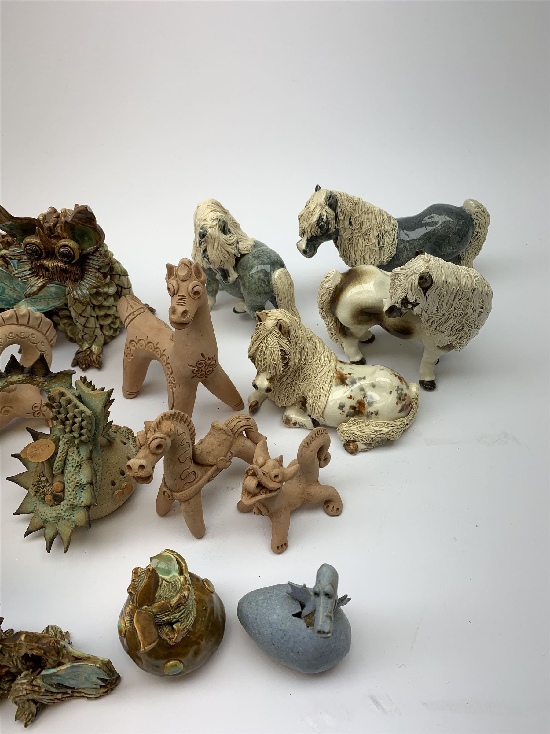 Four Cheval Ceramics figures modelled as ponies, together with a number of studio pottery figures of dragons. 