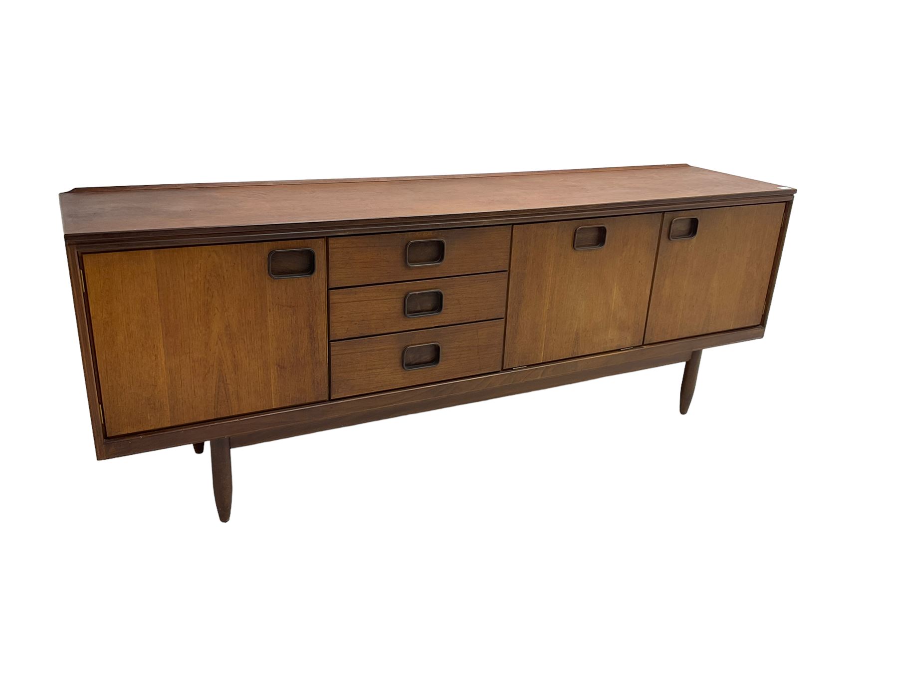 William Lawrence of Nottingham - mid-20th century teak sideboard, with low gallery back over three short drawers and a fall front, flanked by two cupboard doors, enclosing shelves, raised on tapering cylindrical supports, makers mark stamped inside drawer