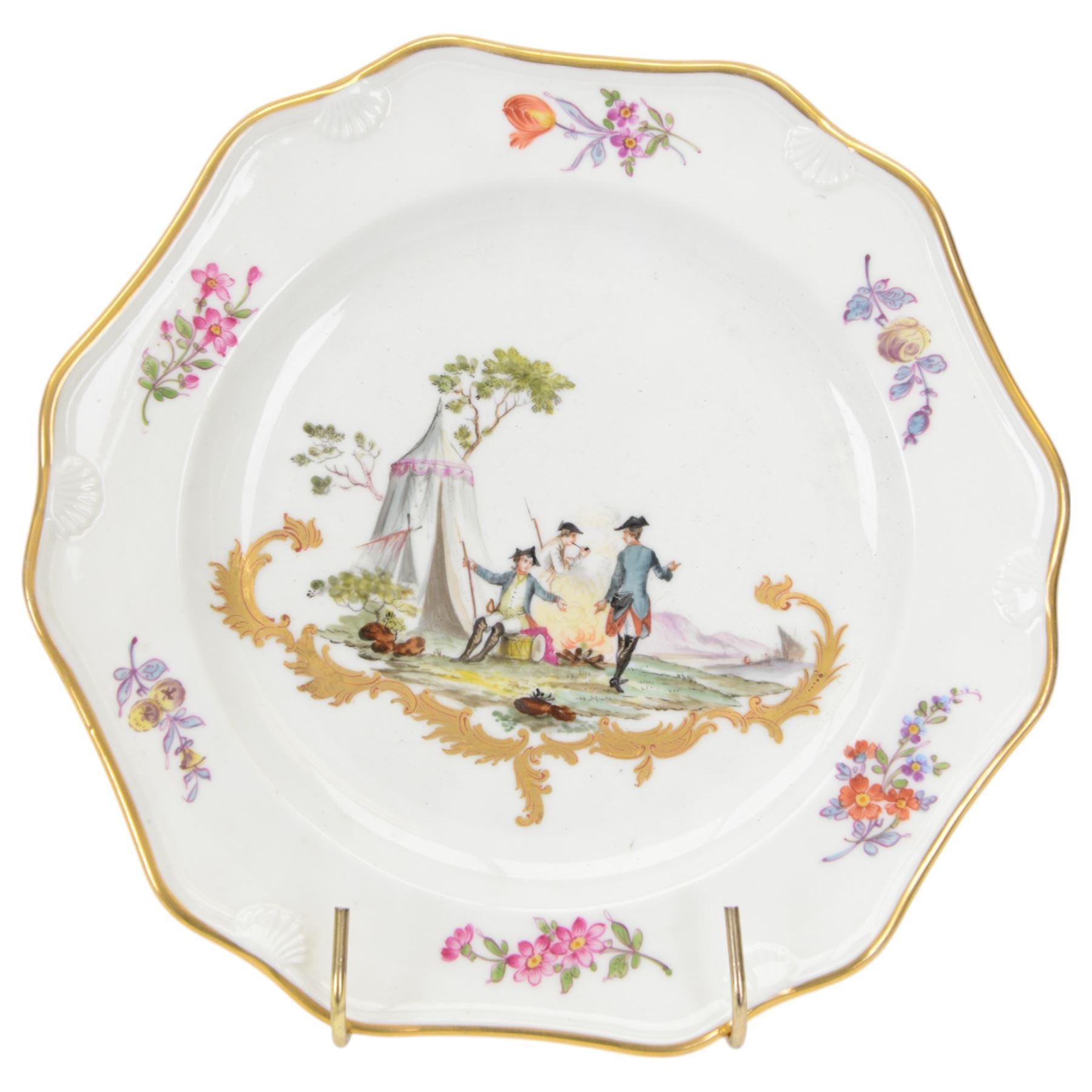 Pair of early 19th century cabinet plates, possibly Derby replacements for Frankenthal, each of faceted form with moulded shell detail to rim and gilt edge, the centre painted with an encampment with soldiers at rest, above a gold rocaille scroll and surrounded by floral sprigs to the rim, with gilt mark beneath for Frankenthal, Carl Theodor, D24cm