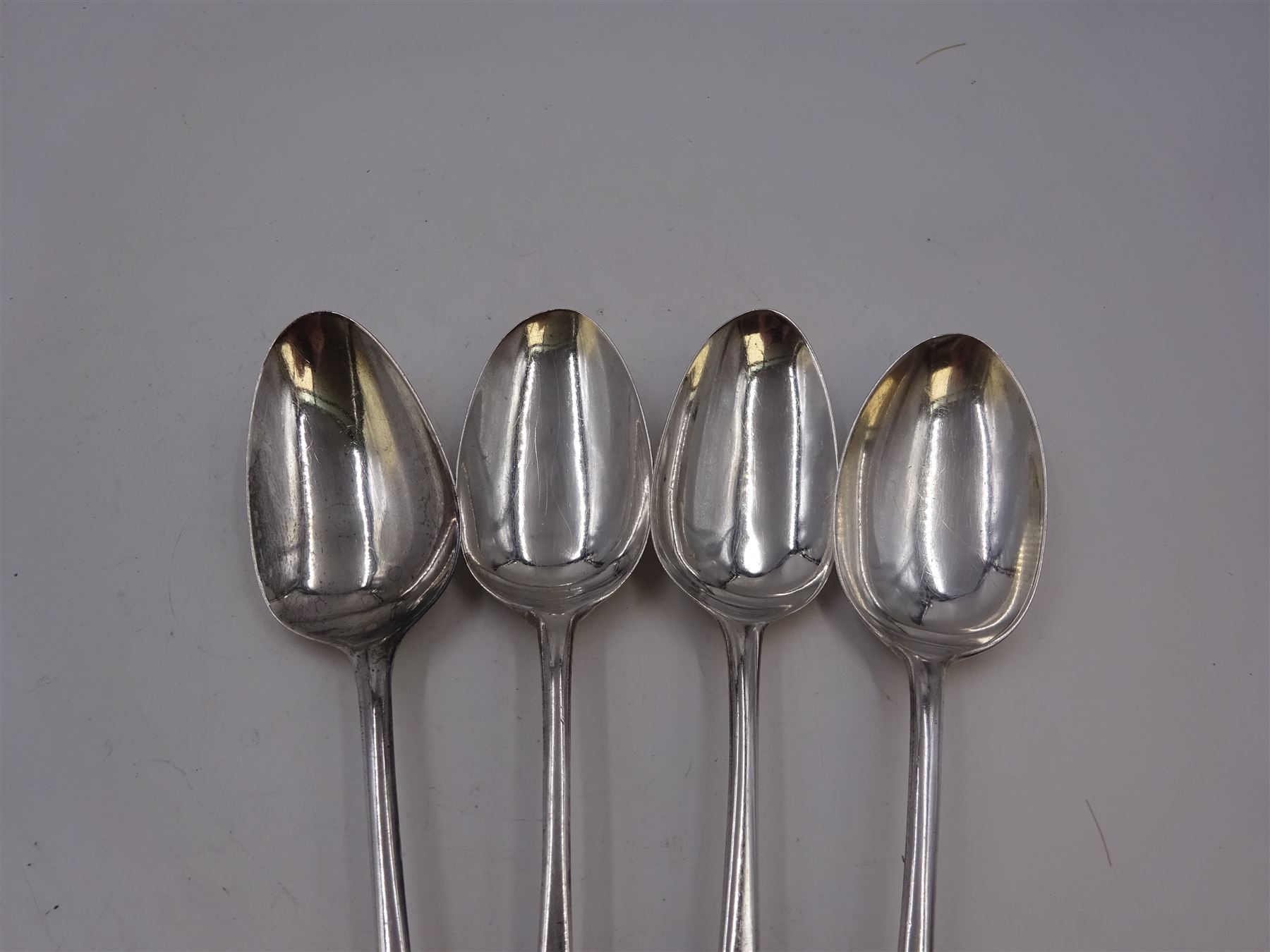 Two George III silver Old English pattern table spoons, the first example hallmarked Peter & Ann Bateman, London 1793, and the second example hallmarked George Smith (III) & William Fearn, London 1792, together with an Edwardian Old English pattern table spoon, hallmarked John Round & Son Ltd, Sheffield 1904, and a similar spoon, maker's mark worn and indistinct (4)