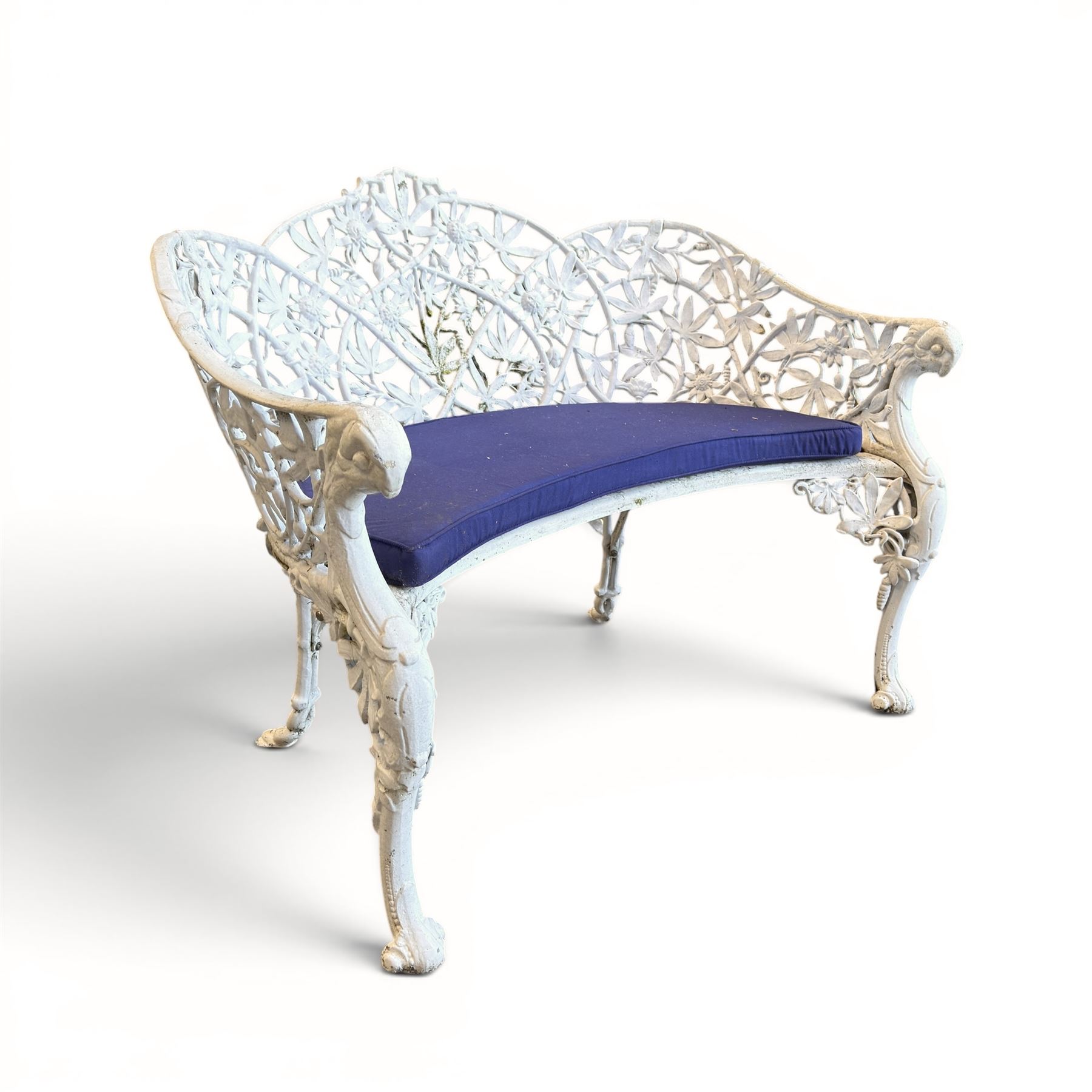 Victorian revival cast two seat garden bench, scrolling lattice back with flower heads, terminating to rams heads arms, curved pierced seat, finished in antique white paint
