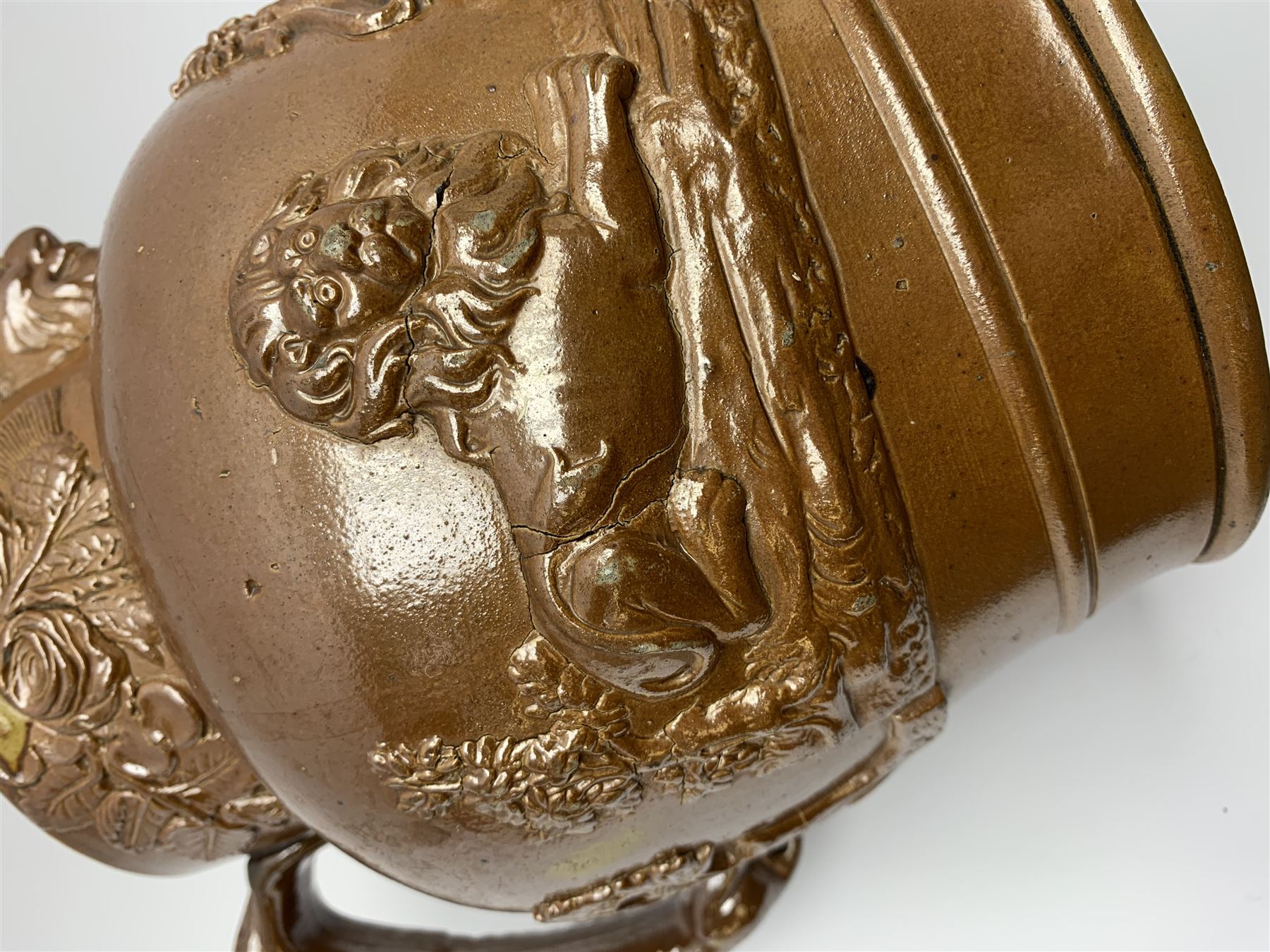 19th century salt glazed stoneware jug, with mask spout and greyhound modelled handle, the body decorated in relief with Royal Coat of Arms flanked by lions, the rim with the flowers of the union, roses, thistles and shamrocks, H26.5cm