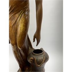 An Art Nouveau Goldscheider pottery figure, modelled as a classical female figure stooping to lift a water jar, matt glazed and highlighted in gilt, signed to base E Tell, H64cm. 
 