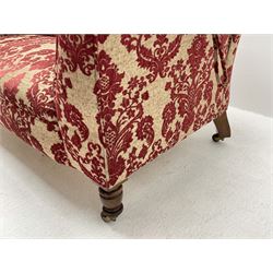 Late Victorian two seat traditional shape settee, adjustable staggered drop end, hardwood framed, upholstered in red and pale gold fabric with raised stylised floral pattern, turned oak front supports and splayed walnut rear supports with brass and ceramic castors