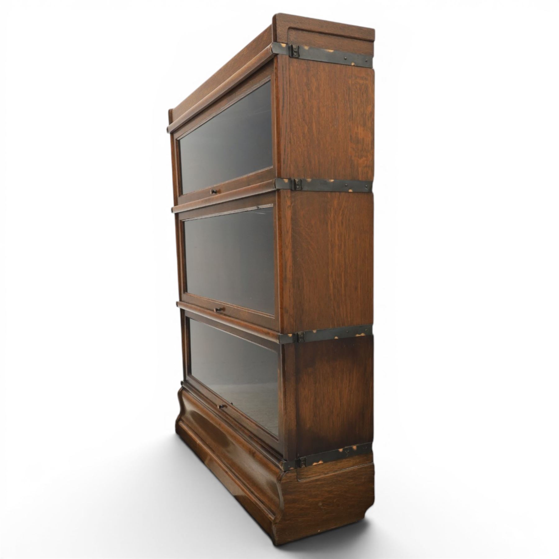 Globe Wernicke - early 20th century oak stacking bookcase, three tiers, lift up glazed doors raised on a plinth base