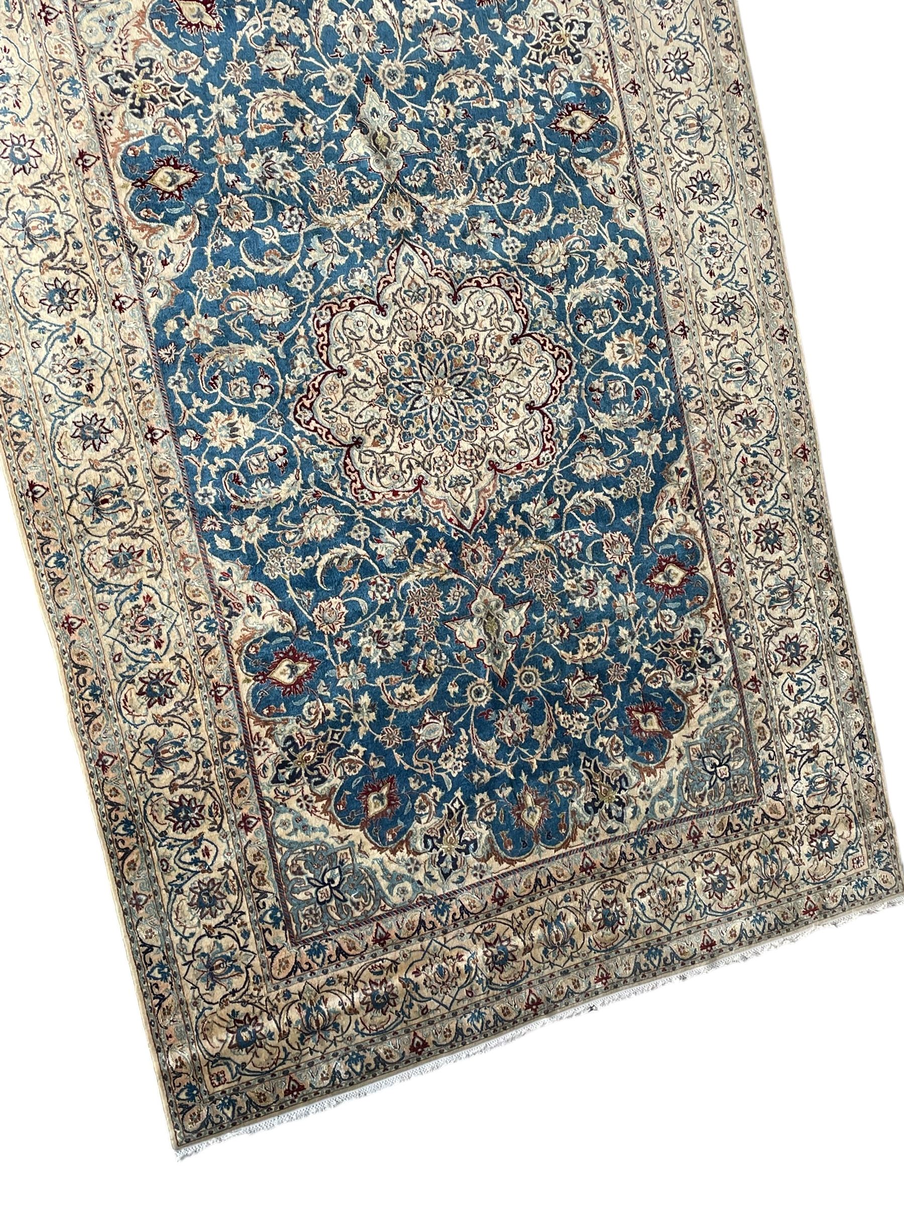 Persian Nain blue and ivory ground rug, wool with silk inlay, overall arabesque design, central medallion surrounded by interlacing and scrolled leafy branches and palmettes, the scrolling border decorated with stylised plant motifs, within guard stripes