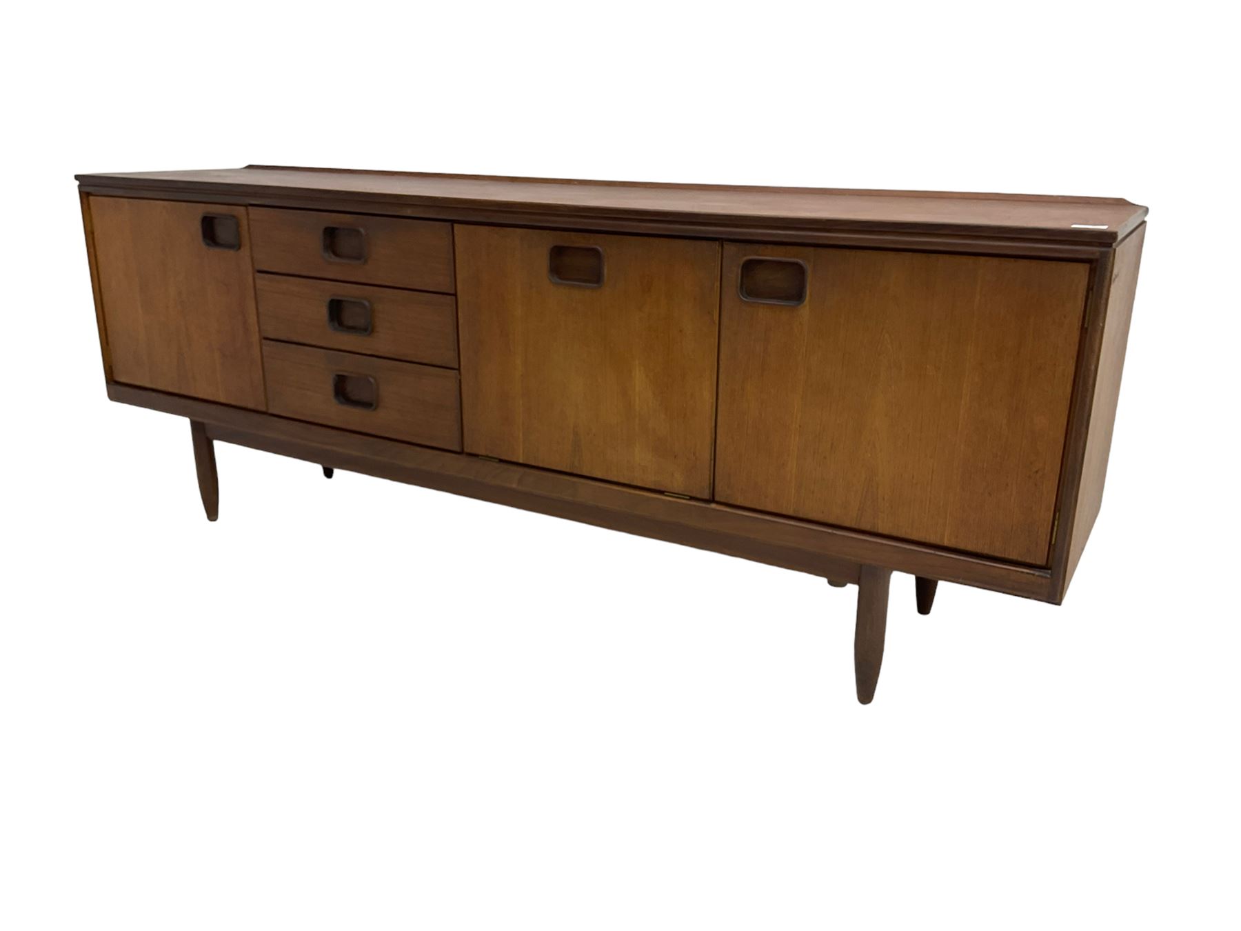 William Lawrence of Nottingham - mid-20th century teak sideboard, with low gallery back over three short drawers and a fall front, flanked by two cupboard doors, enclosing shelves, raised on tapering cylindrical supports, makers mark stamped inside drawer