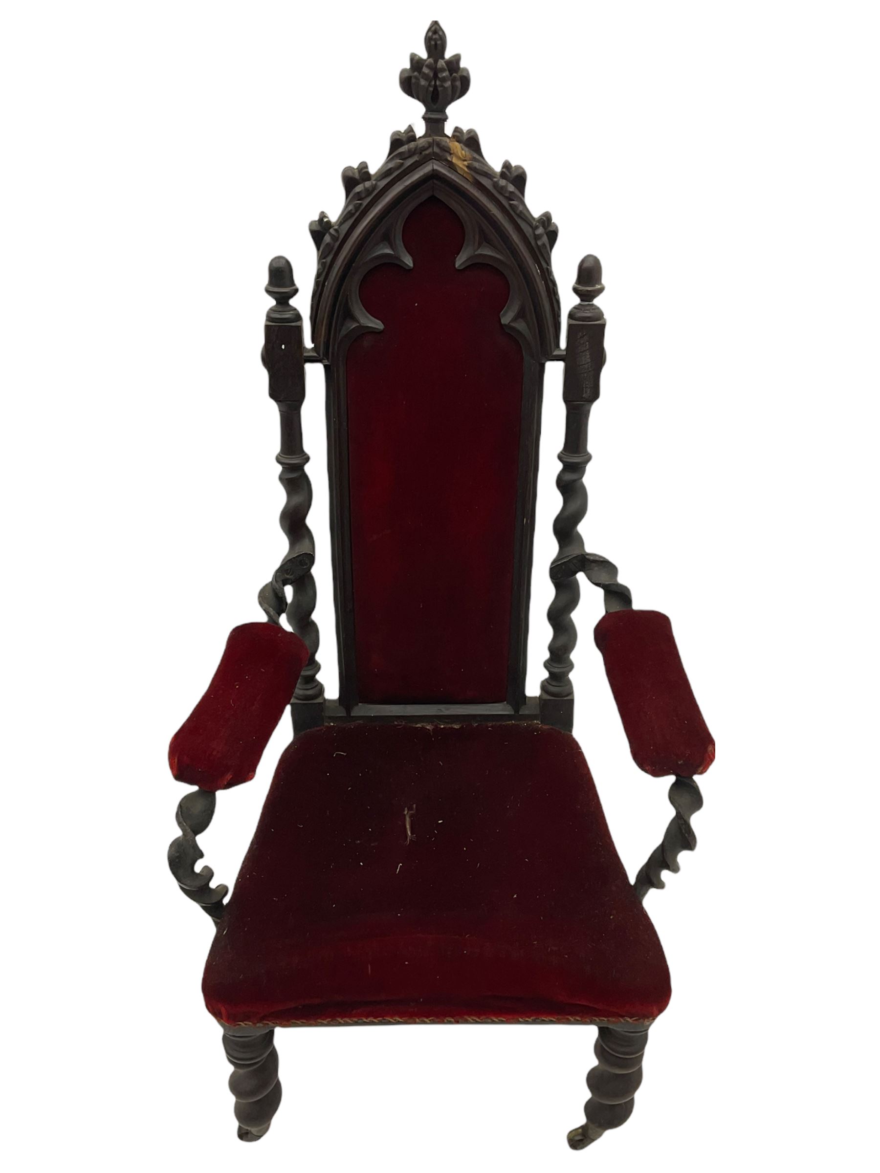 Victorian oak and wrought metal Gothic open armchair, the pointed arched back carved with foliate, cusped inner arch upholstered in red, spiral turned uprights and supports, with arms made of spiral forged metal