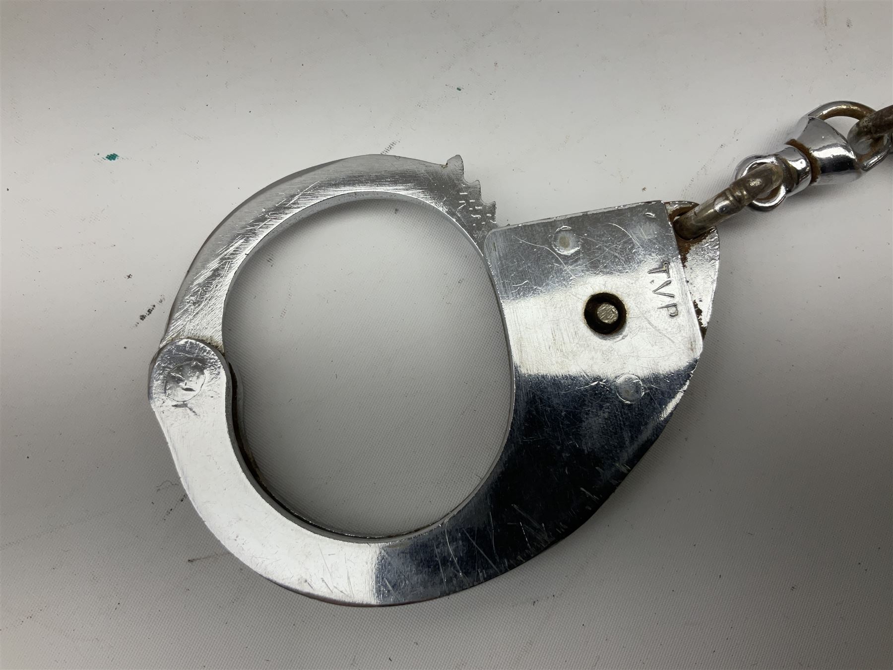 British Transport Police Custodian helmet with Queen's Crown plate; Hiatt & Co ebonised hardwood patrol truncheon; and pair of Hiatts 1960 hand-cuffs (3)