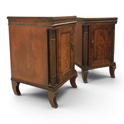  Pair of Regency mahogany bedside cabinets, rectangular top above a central cupboard door with flame mahogany veneer, flanked by spirally turned column uprights, raised on shaped supports