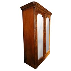 Victorian figured walnut double wardrobe, projecting moulded cornice over twin arched silvered mirrored doors, fitted with hanging rail and drawer with campaign style handle, on plinth base
