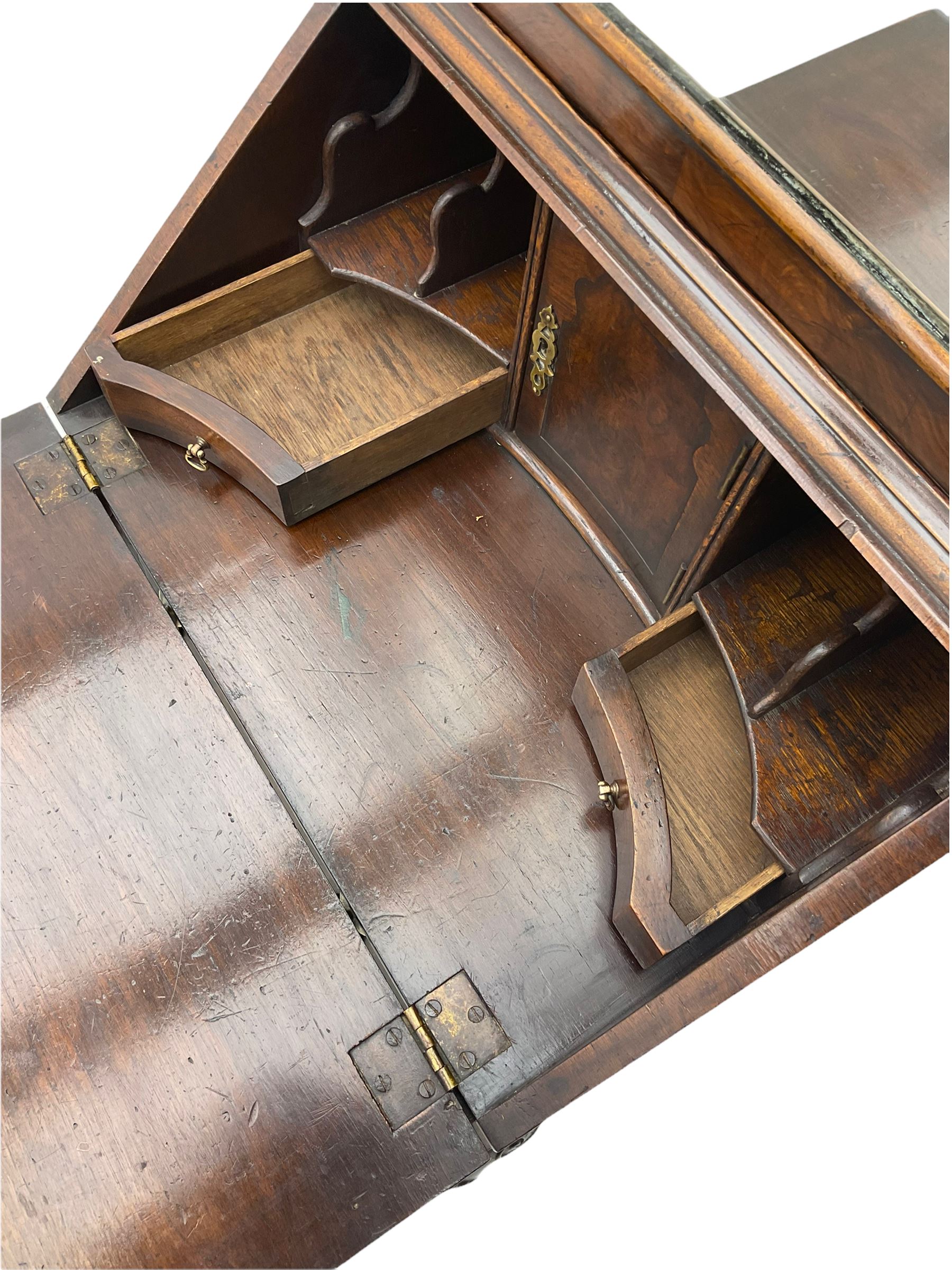 Small early 20th century Queen Anne style bookcase on bureau secretaire, the moulded arched pediment over mirrored door in shaped frame, the bureau fitted with fall front enclosing curved fitted interior, cushion moulded drawer over single drawer, on scroll and shell carved cabriole supports