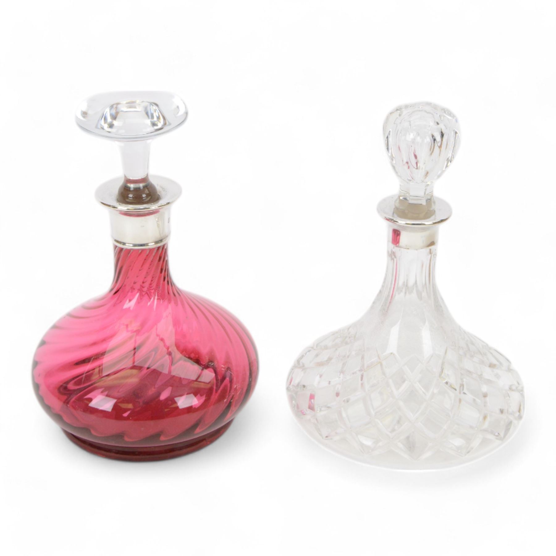 Two modern silver mounted glass decanters, the first a cranberry glass example, with fluted body, clear stopper and silver collar, hallmarked Barker Brothers Silver Ltd, Birmingham 2001, together with a clear cut glass example with silver collar, with import marks for London 1985, tallest H25.5cm