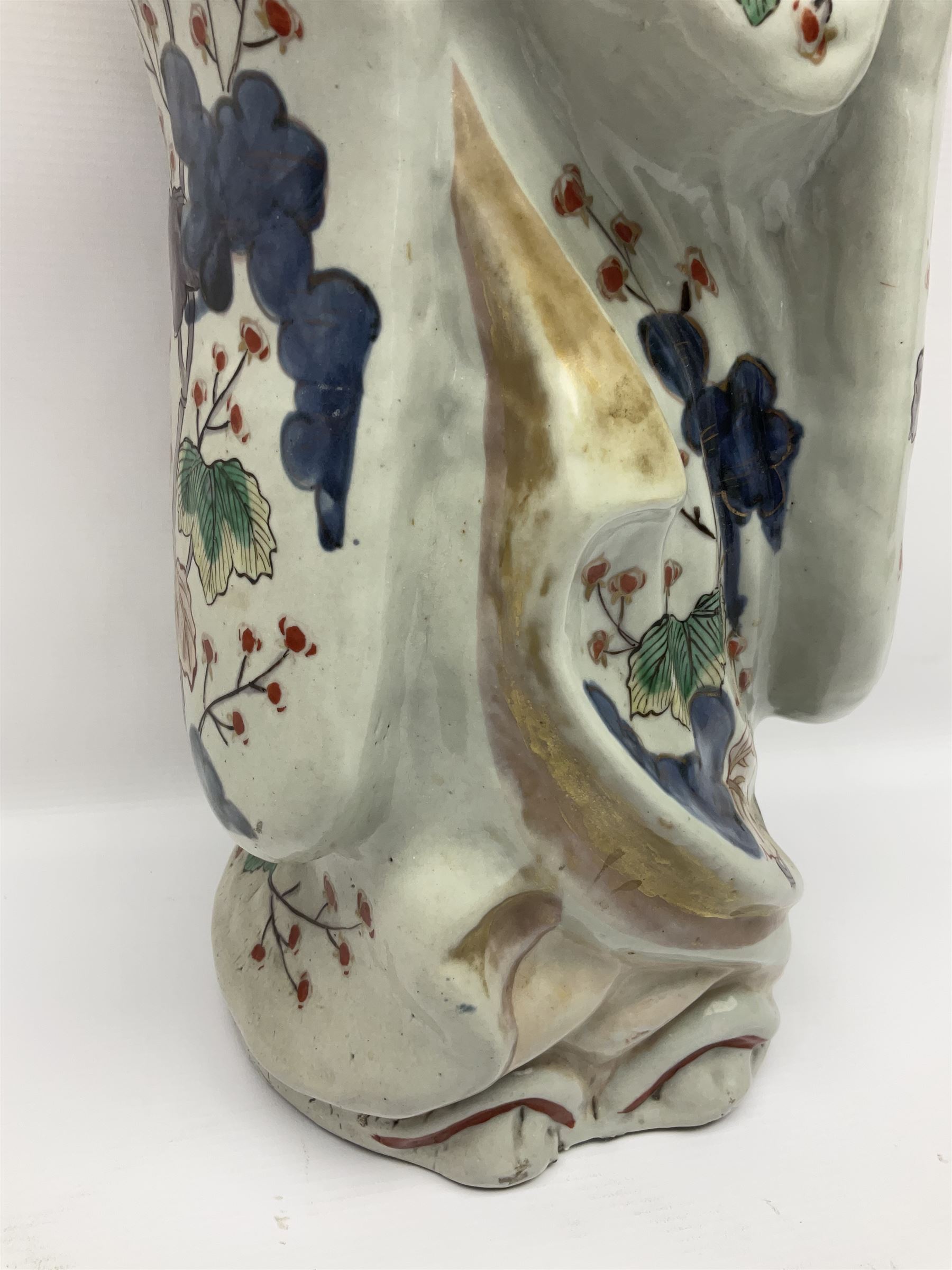 Large Japanese Imari porcelain figure, modelled as a Bijin, wearing a long kimono decorated with apple blossom and leafy branches on a white ground, with gilt detailing, possibly Edo period, H63cm