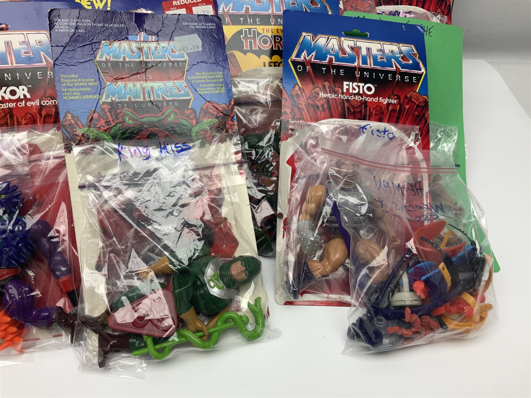 Thirty-one Masters of the Universe He-Man figures re-bagged on original backing cards;  two others lacking backing cards; boxed Modulok figure; bag of weapons and accessories; Roton, two horses and two battle cats; 1986 & 1987 Annuals; Ladybird and other story books; Panini sticker album; instructions etc