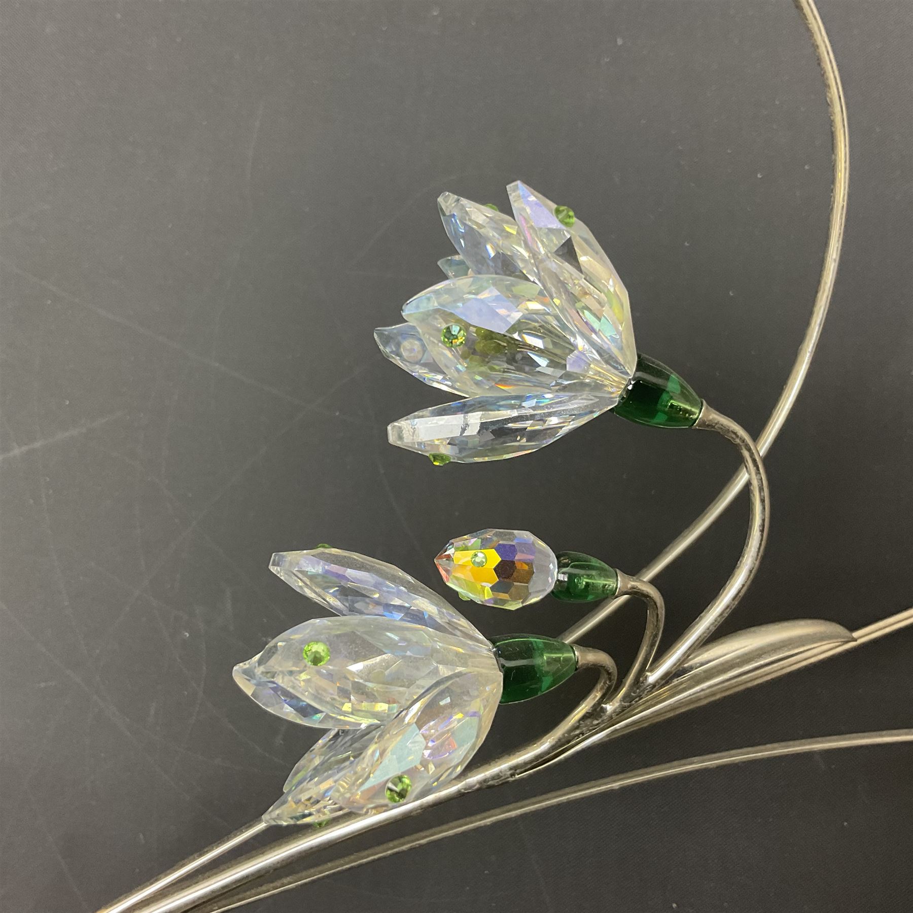 Eleven Swarovski Crystal flowers, to include violet, sunflower, delphinium, forget-me-not and lily-of-the-valley, each on stylised metal stems, tallest H23cm