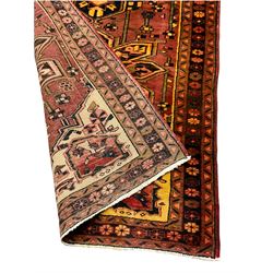 Persian Heriz golden red ground runner, then main field decorated with three stylised medallions and various motifs, three band border decorated with flower heads 