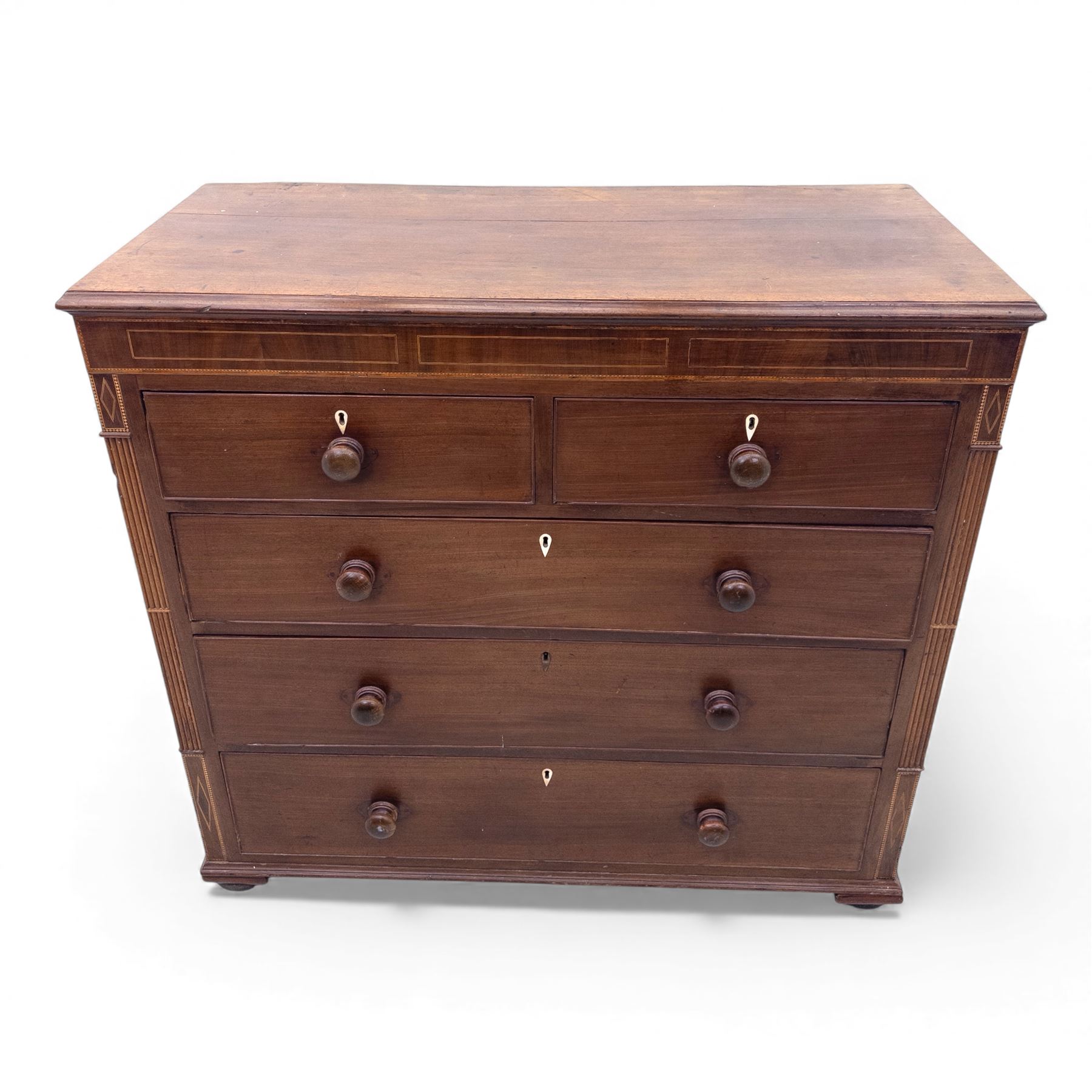 Early 19th century mahogany chest of drawers, the rectangular top with boxwood line inlay above two short and three long graduating drawers, each with turned wooden knobs and bone escutcheons, flanked by fluted uprights with diamond inlaid panels, on shaped bracket feet