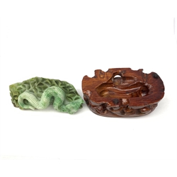 A carved jade serpent on stylised base, with accompanying carved stained wooden stand, figure L11cm. 