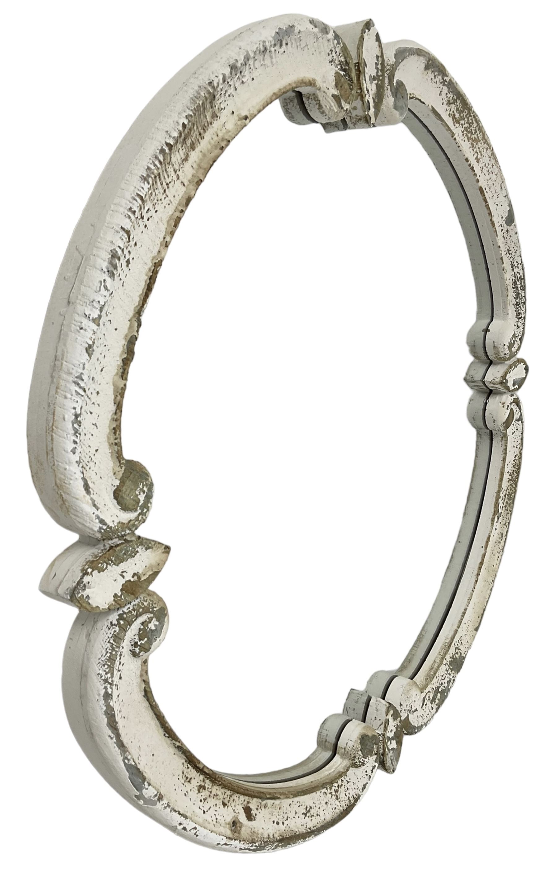 French design carved pine wall mirror, the frame in the form of conforming c-scrolls, plain mirror plate, in distressed white paint finish 