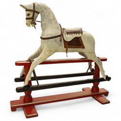 20th century carved and painted rocking horse, with original dappled paint finish, studded leather saddle and reins, on later red and black swing frame