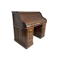 Early 20th century oak twin pedestal desk, tambour roll top enclosing small drawers and correspondence pigeon holes, fitted with seven drawers and two slides, on plinth base
