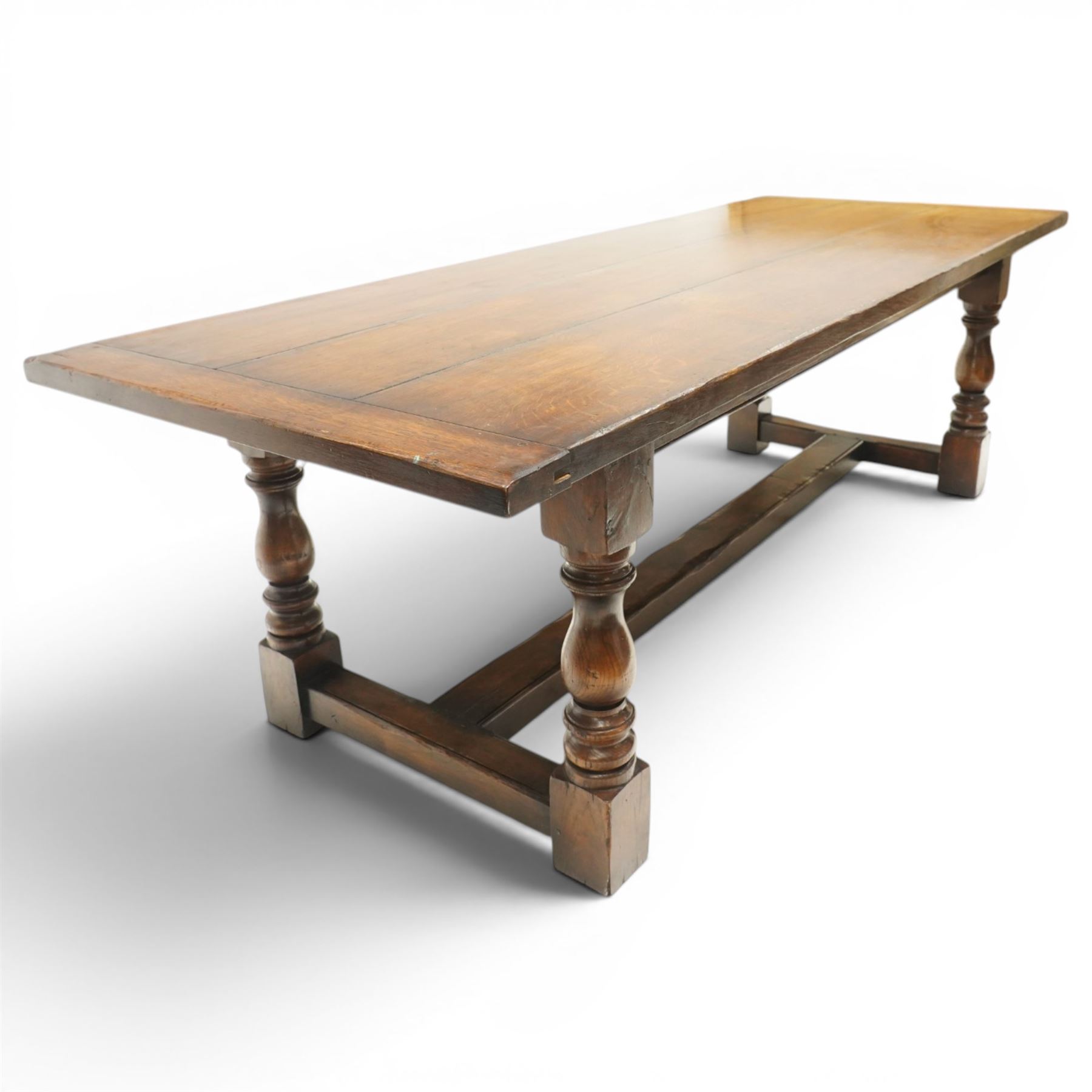 17th century design 8ft dark oak refectory dining table, the rectangular top raised on four turned baluster supports united by H-stretcher