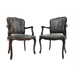  Pair of French design open armchairs, the moulded frame carved with flower heads, upholstered seat, back and arms, on cabriole supports