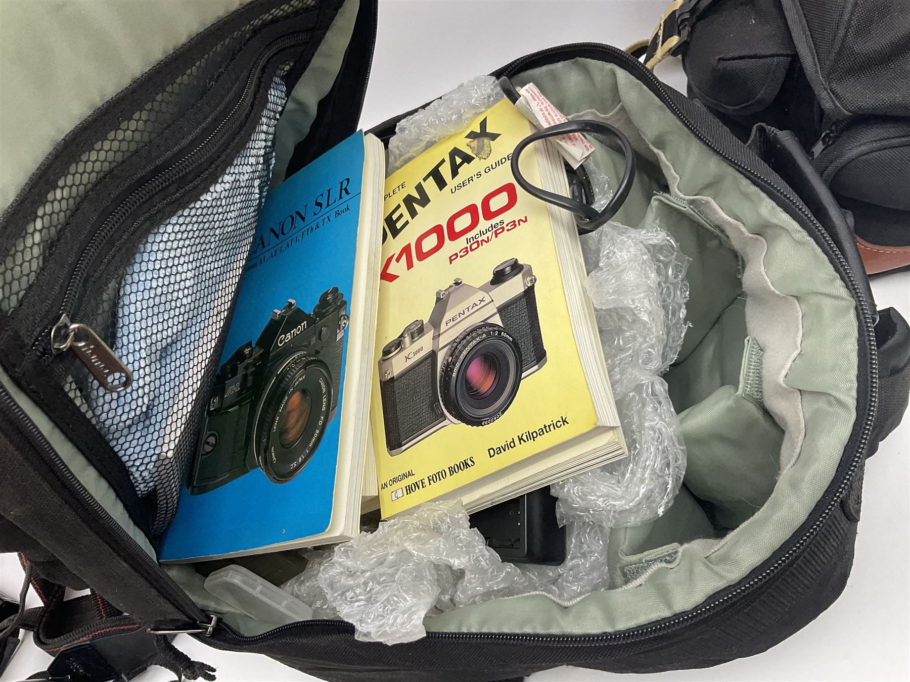 Four camera bodies, to include, Ricoh KR-10 serial no. 38826, Pentax MZ-M serial no. 4185969 with 'SMC Pentax- M 1:3.5 28mm' lens, Canon EOS500 serial no. 080927, with 'Sigma Zoom 100-300mm 1:4.5-6.7 DL'  lens etc, with other camera lenses and equipment 