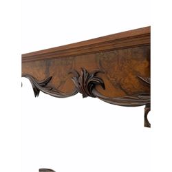 Late Victorian figured walnut mirror, in moulded surround, the shaped aperture surrounded by carved trailing foliate mounts