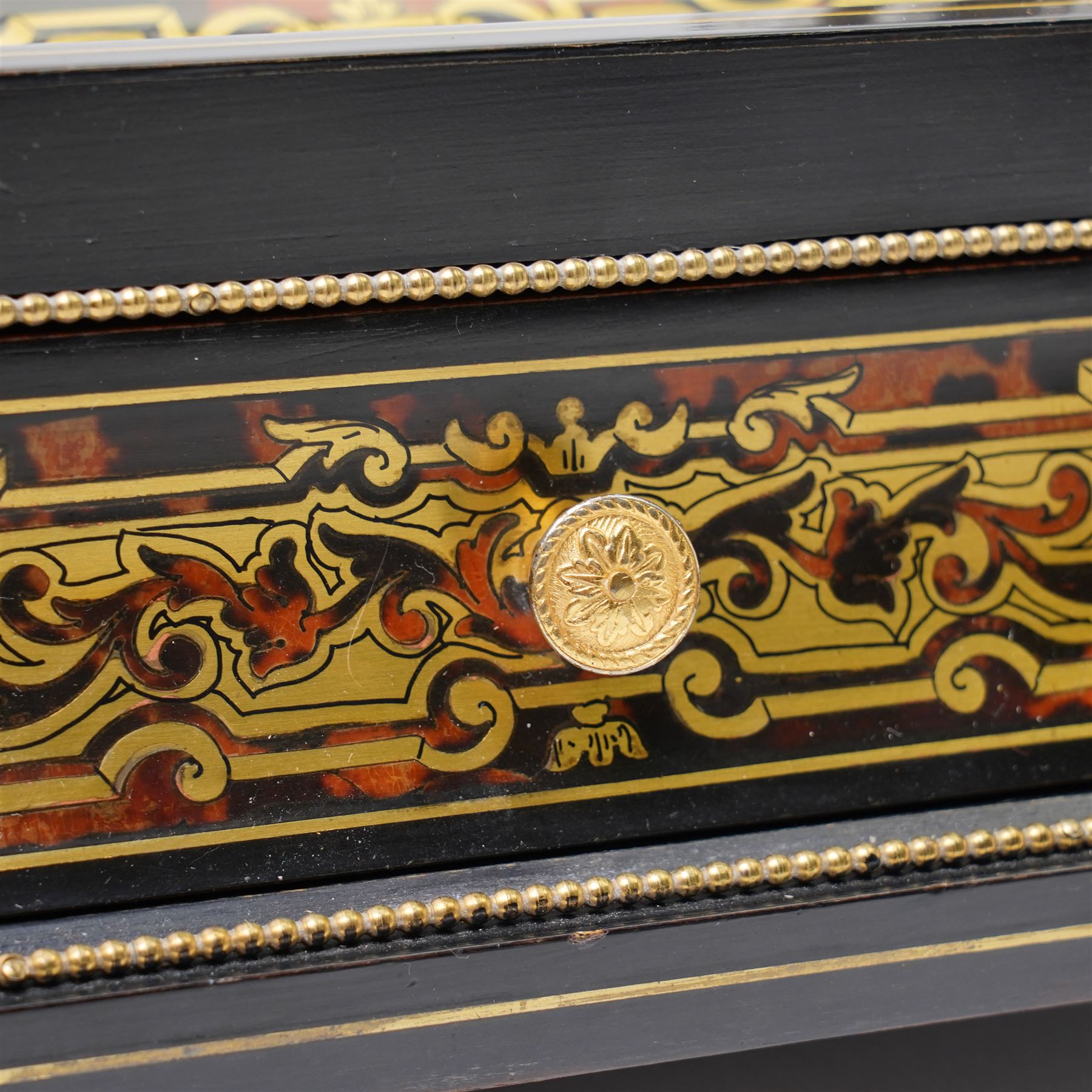 Mid 19th century Boulle inkstand in cut brass and tortoiseshell with beaded decoration with two pen trays and two inkwells on a single drawer base and compressed bun feet W32cm 